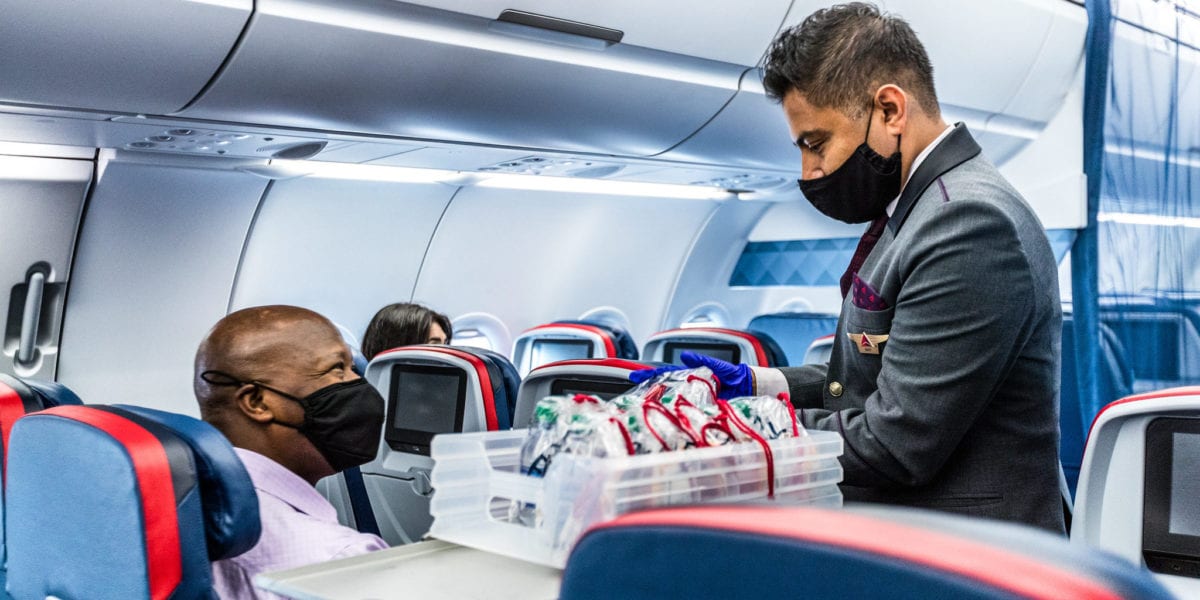 a man wearing a face mask and gloves in an airplane