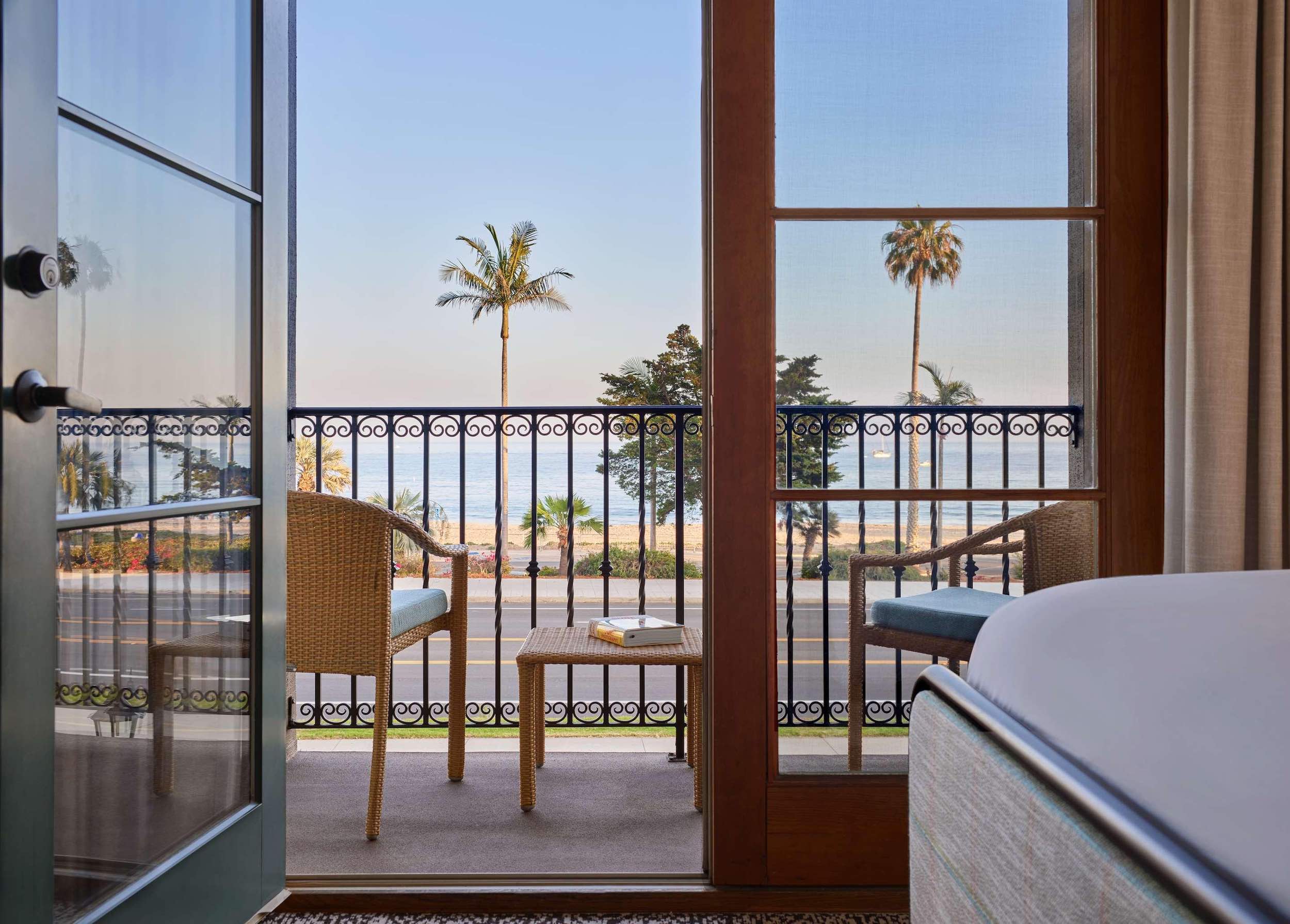 a room with a balcony and chairs and a view of the ocean