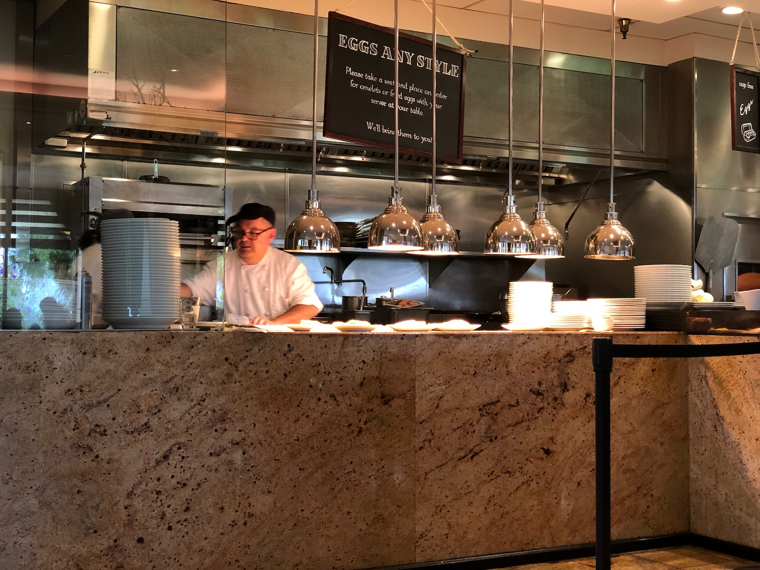 a man standing behind a counter in a restaurant