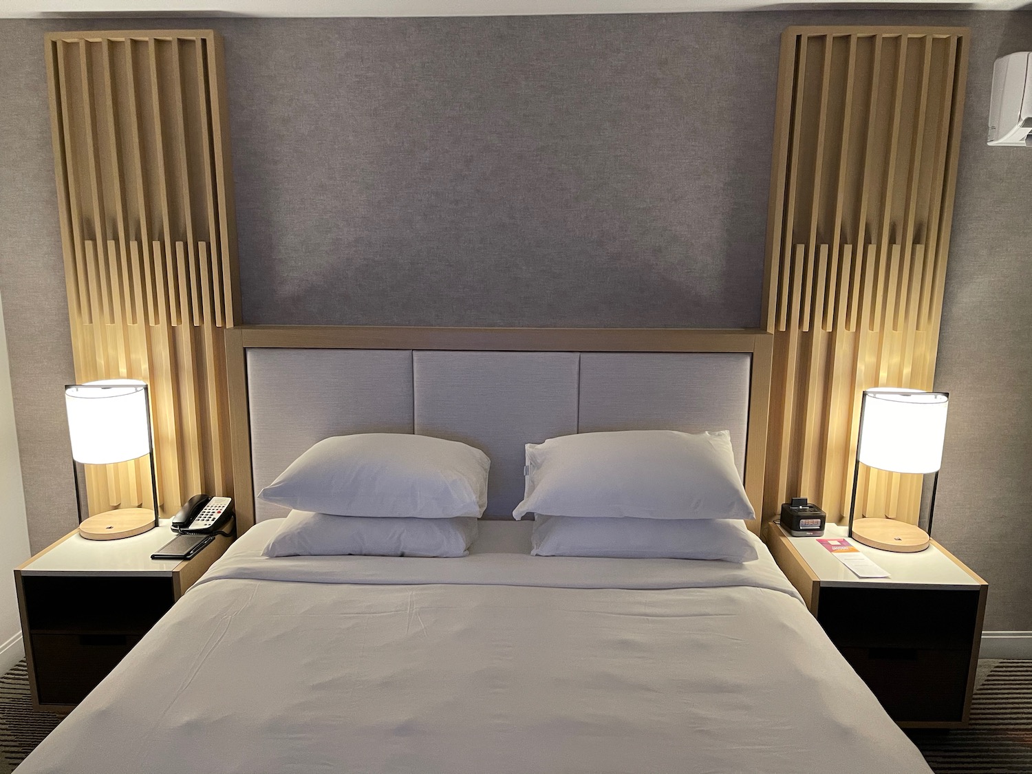 a bed with white sheets and two lamps