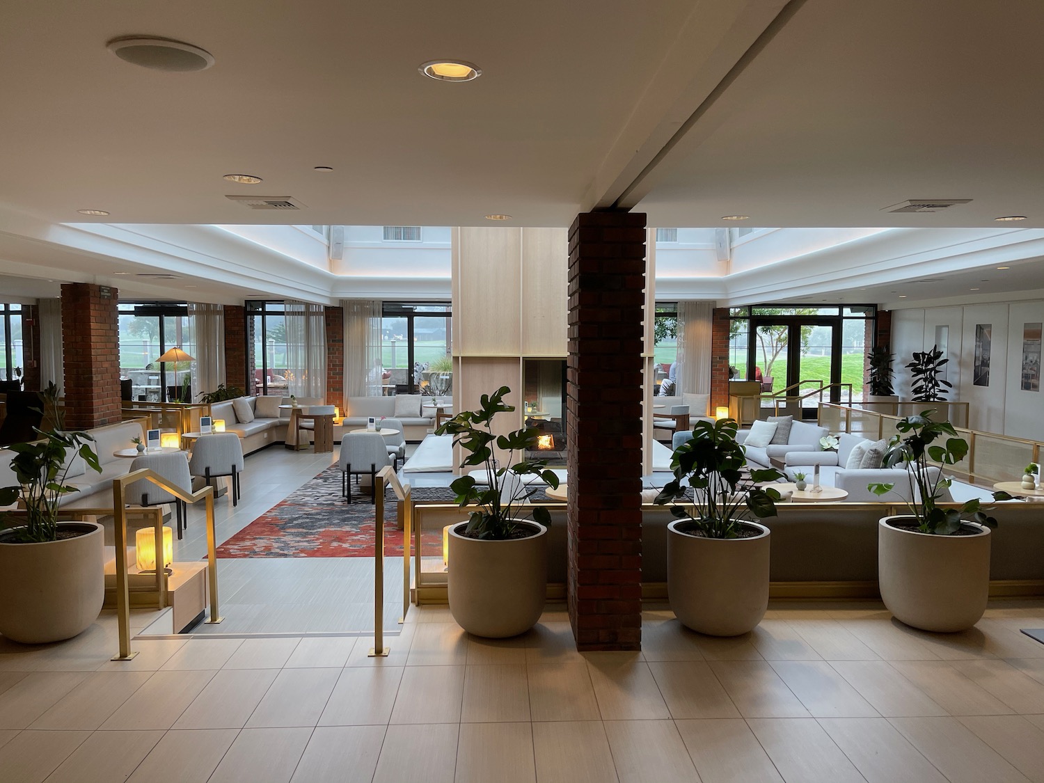 a room with a brick column and tables and chairs