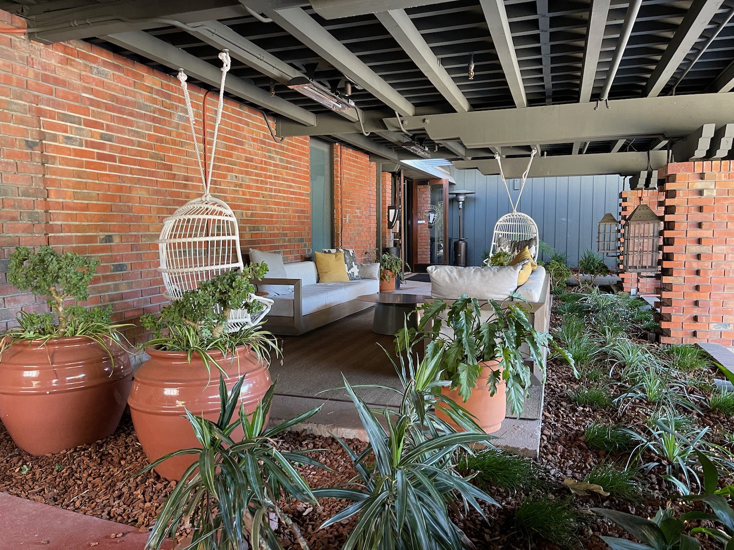 a patio with plants and a brick wall