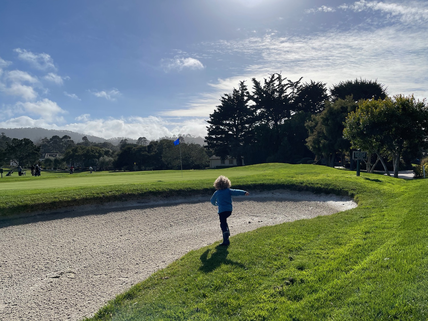 a child standing on a sand trap