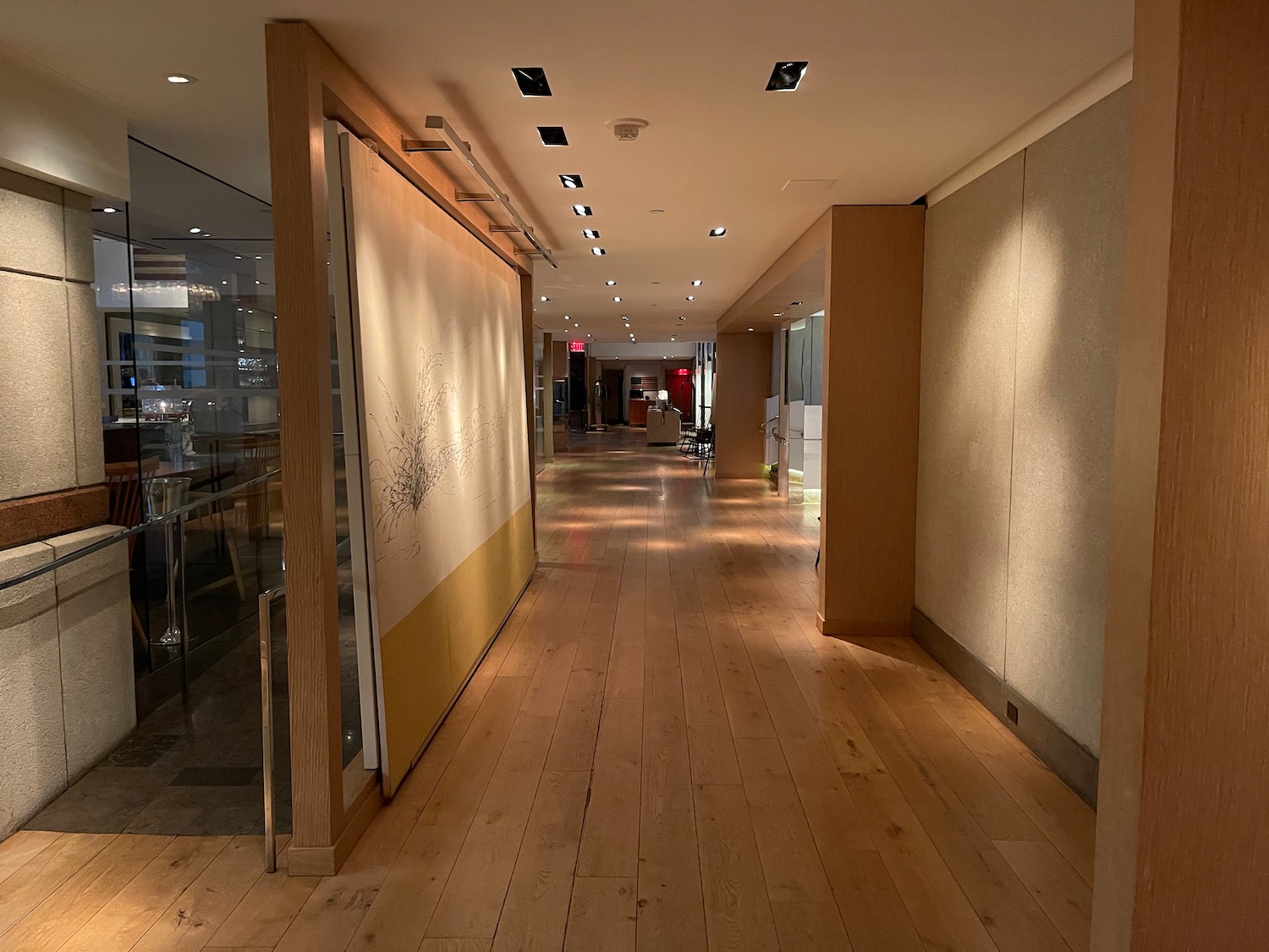 a hallway with a wood floor and a white and yellow wall