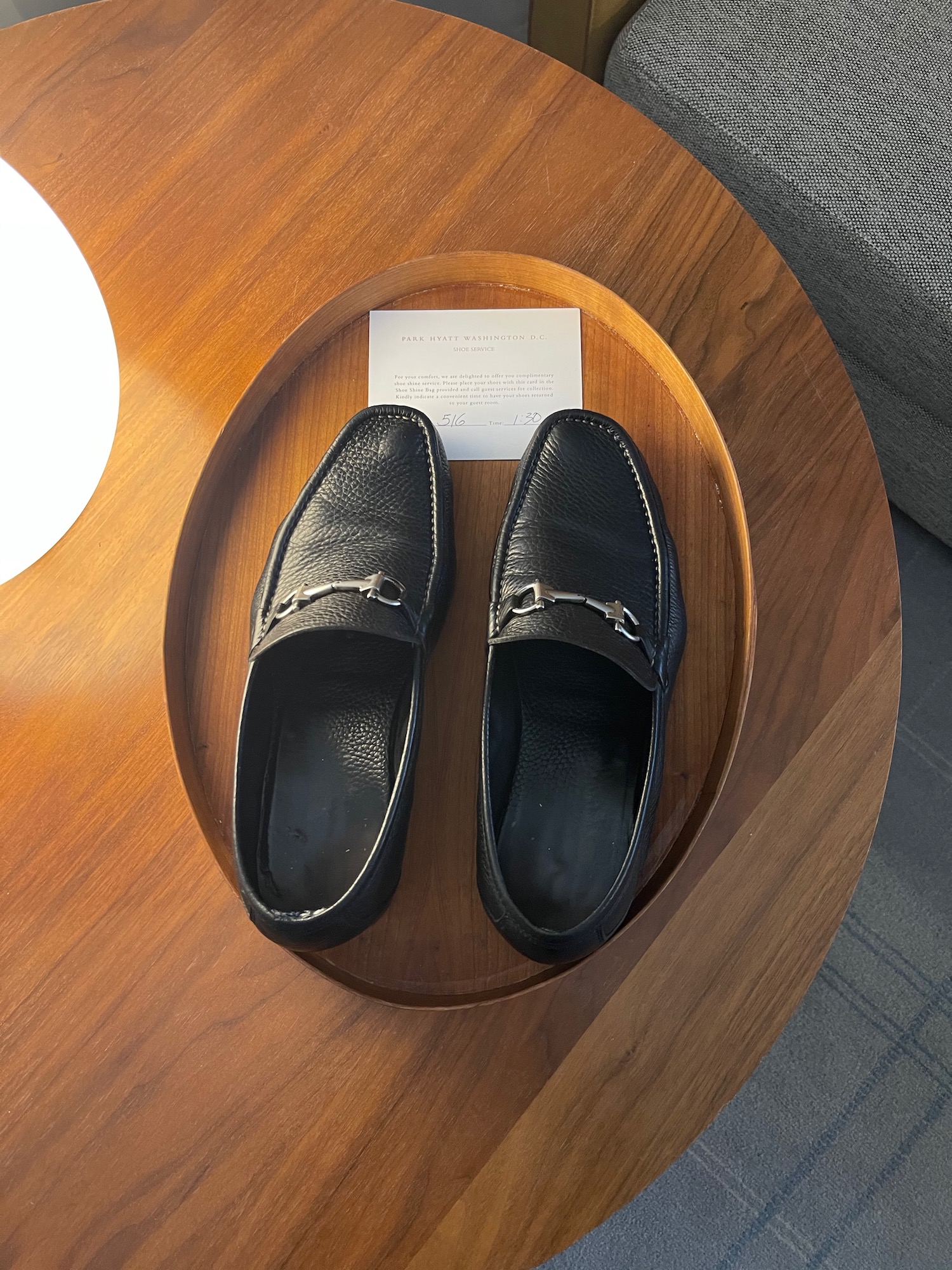 a pair of black shoes on a wooden tray