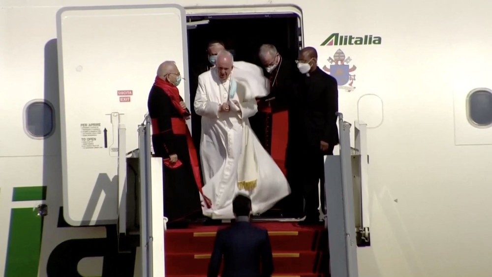 a group of people walking out of a plane