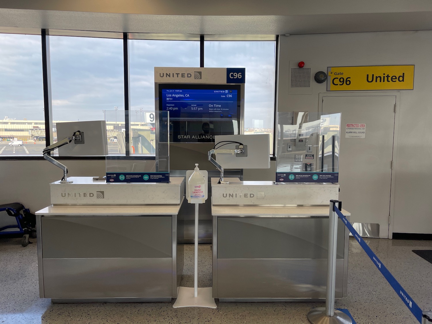 a row of silver counter tops with blue ropes and a sign