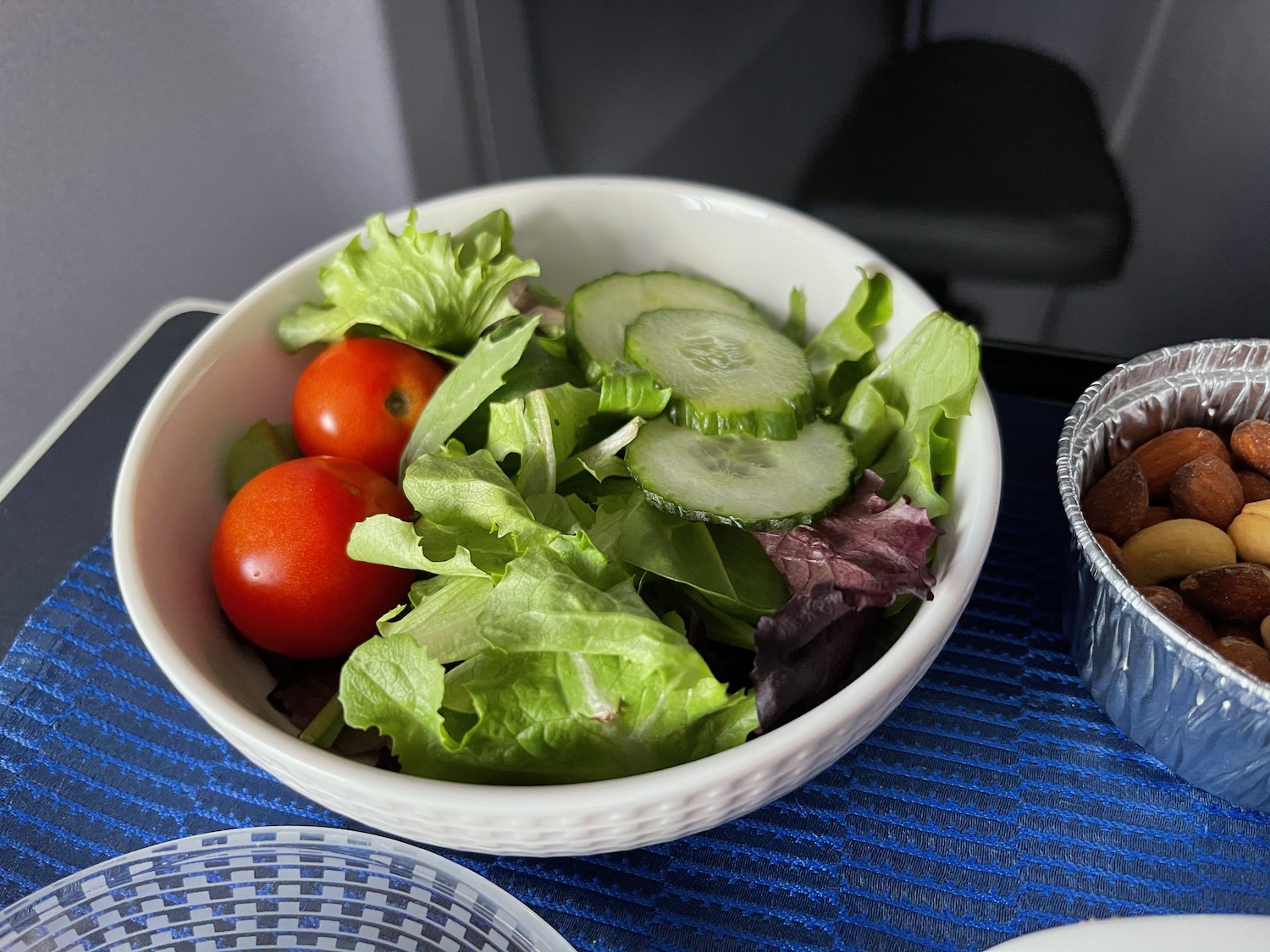 a bowl of salad with tomatoes cucumbers and lettuce