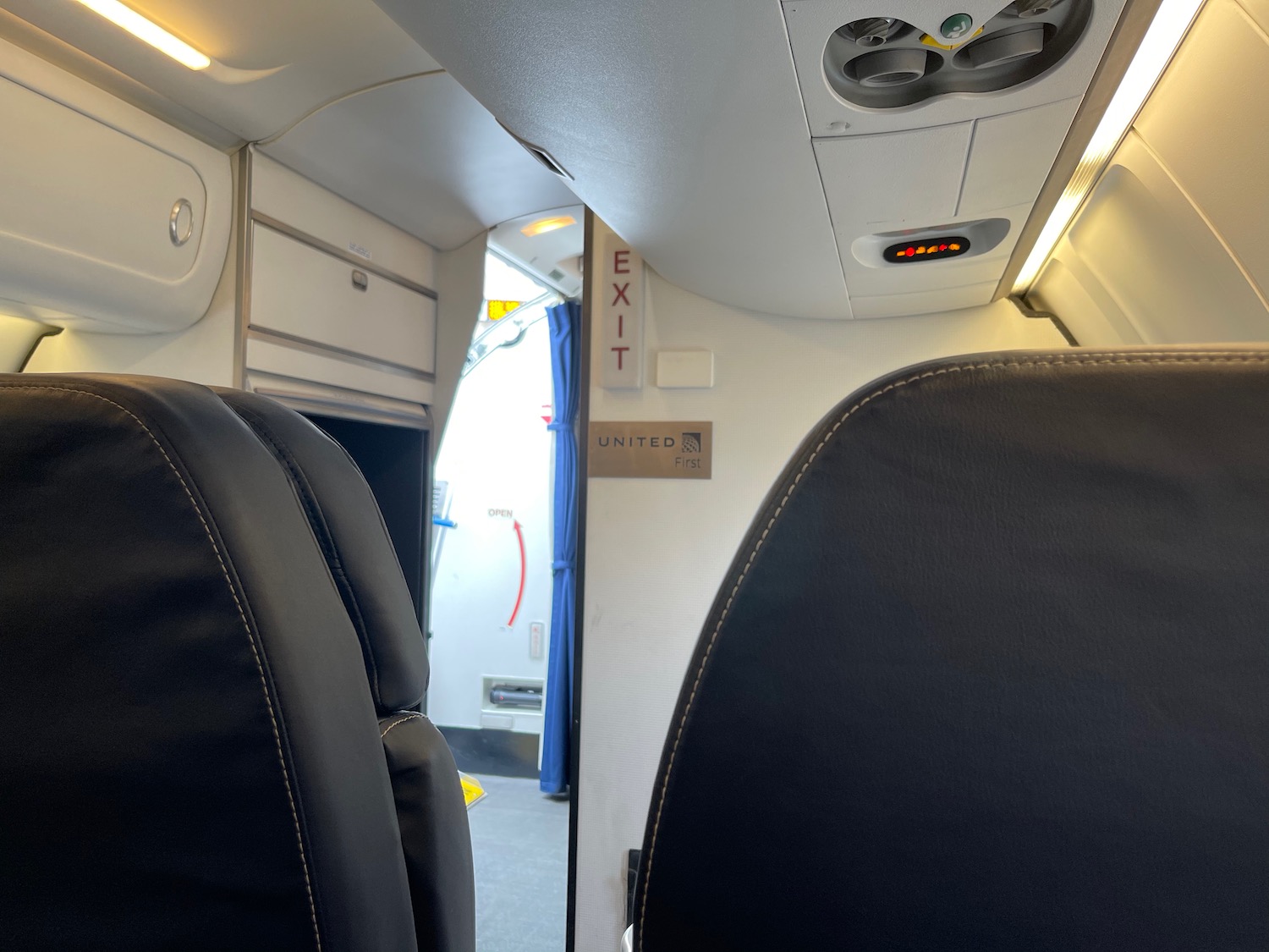 seats in an airplane with a sign and a door