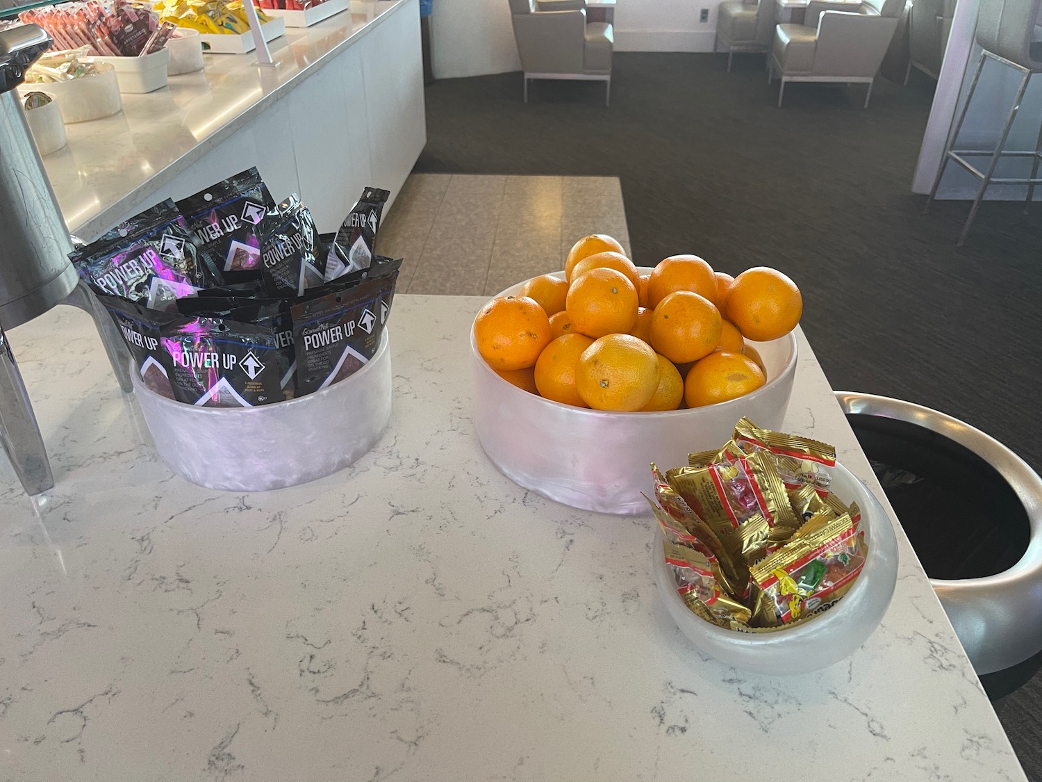 a bowl of oranges and candy on a table
