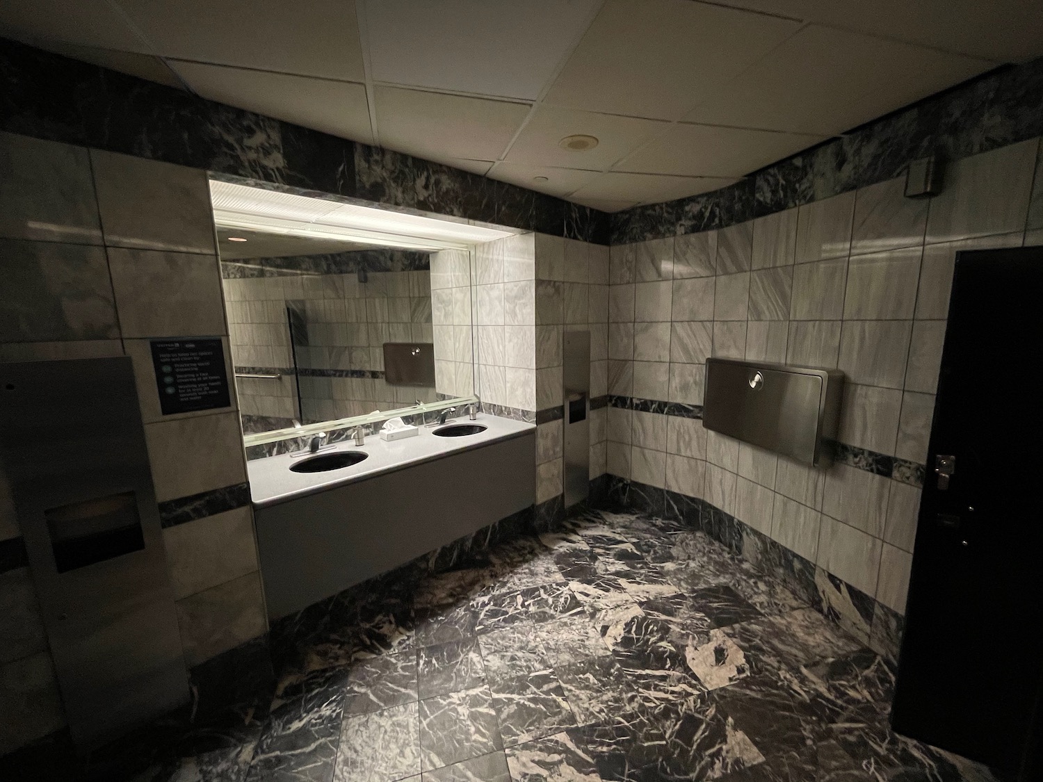 a bathroom with marble tiles and sinks