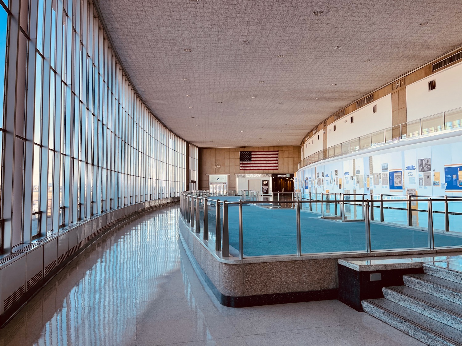 a glass wall with a staircase and a blue carpet