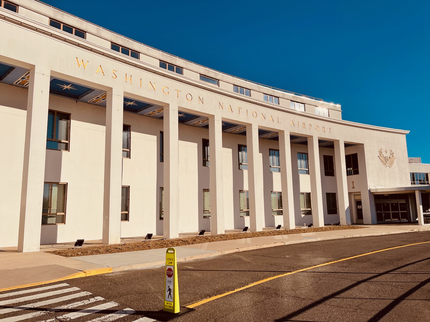 a white building with columns and a yellow sign