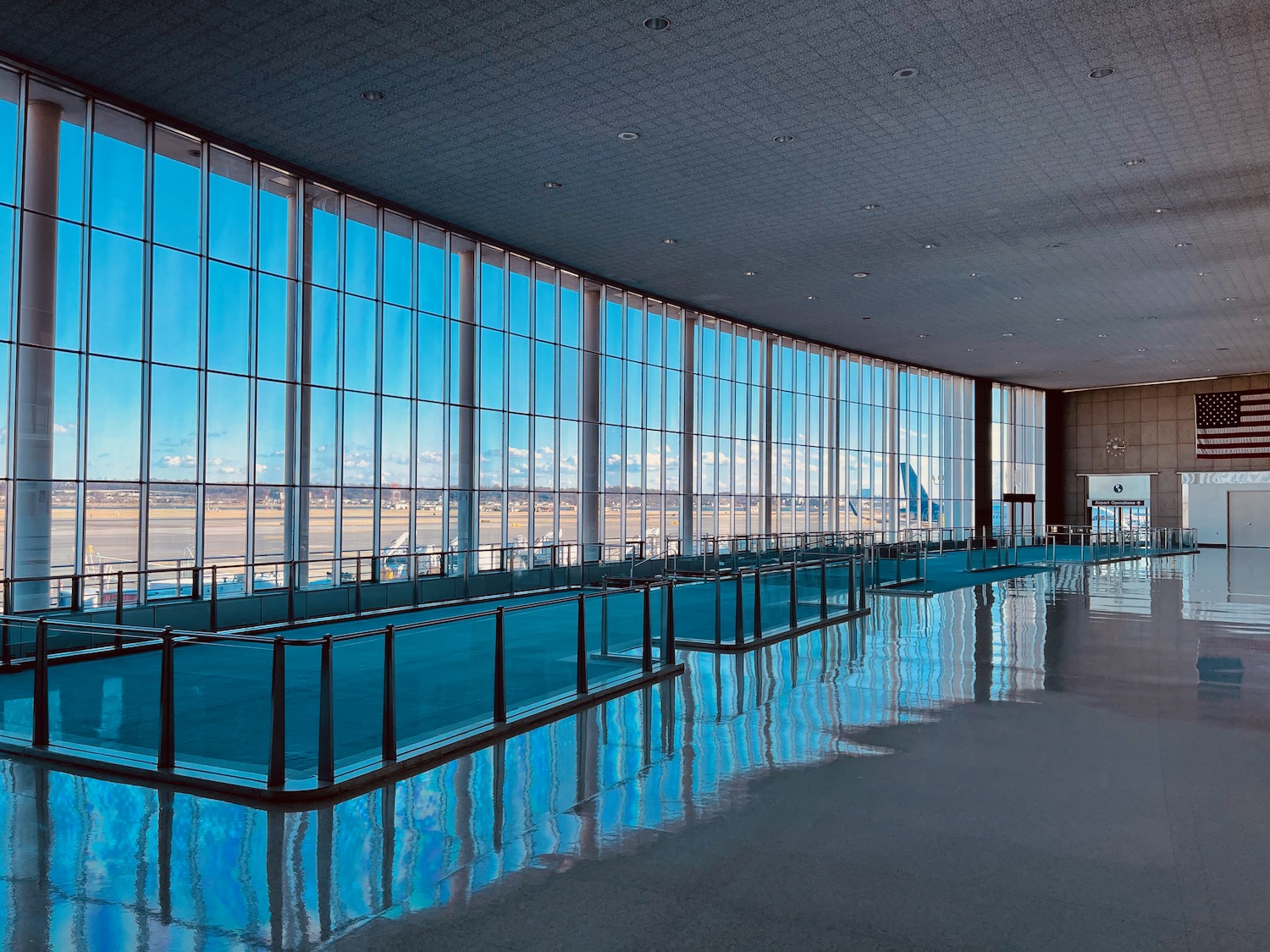 a large glass building with a pool and a runway