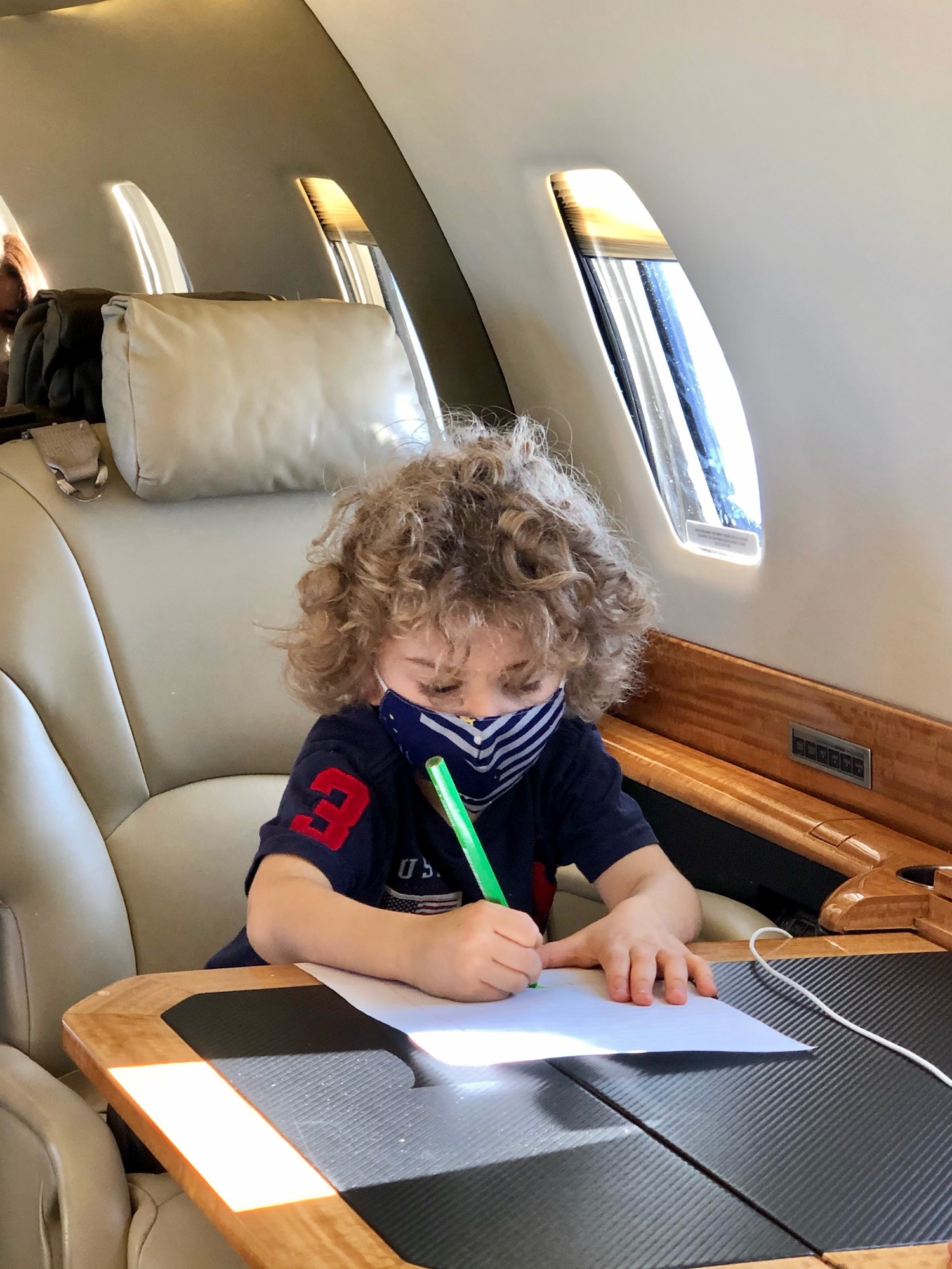 a child sitting at a desk in an airplane