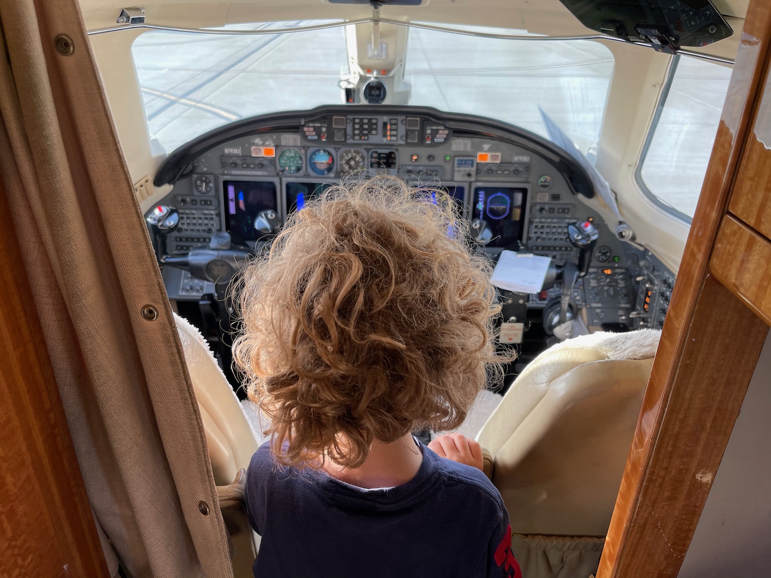 a child looking at the cockpit of an airplane