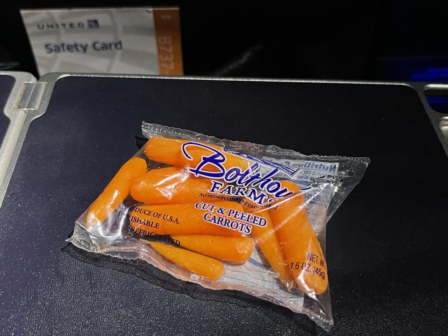 a bag of carrots on a black surface