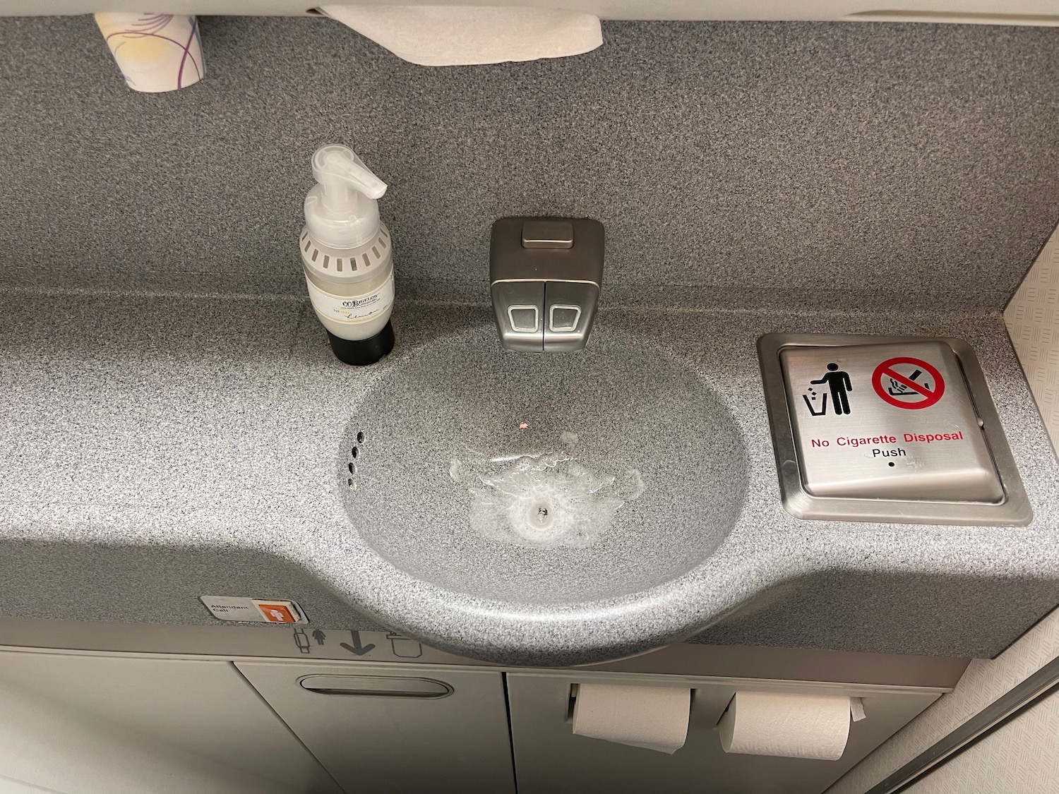 a sink with a soap dispenser and a sign