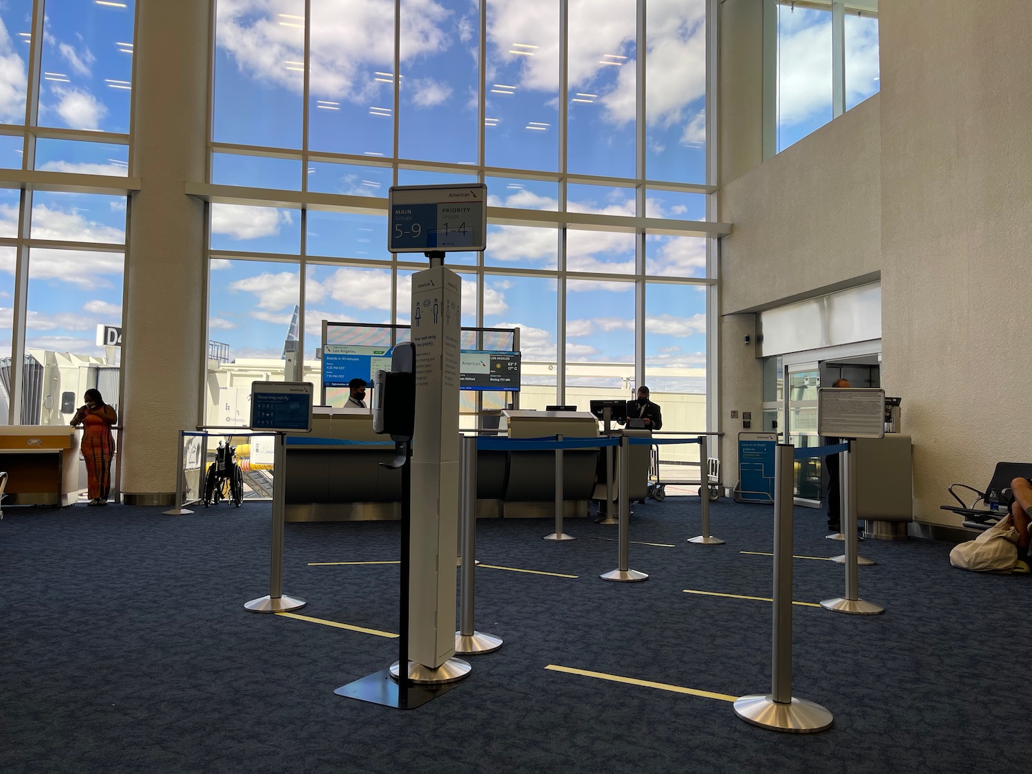 a large glass window with a few people standing in a terminal