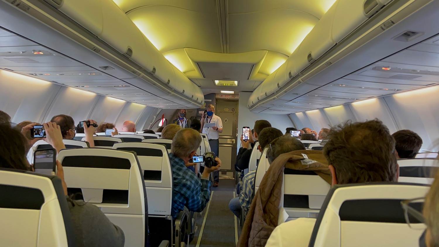 a man standing in an airplane with a group of people