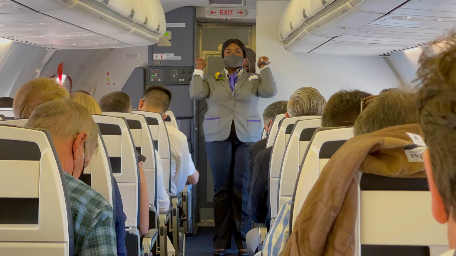 a woman standing in a plane with a mask on