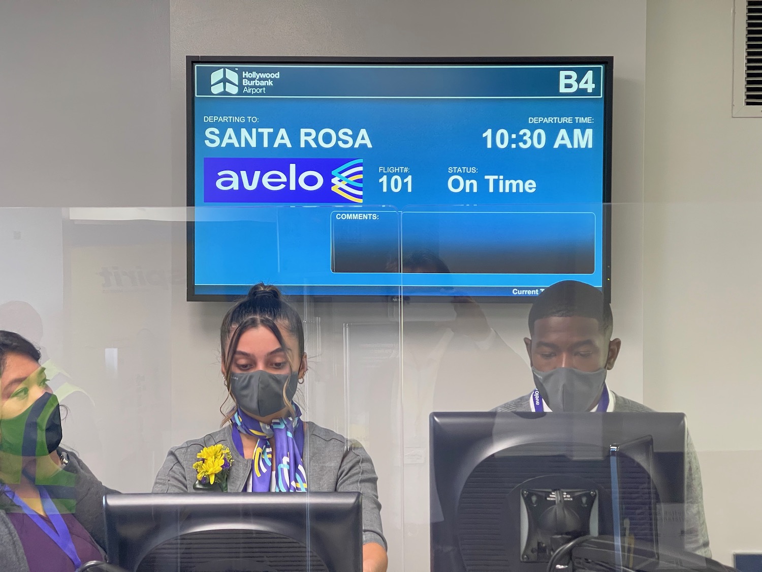 a man and woman wearing masks and looking at computers