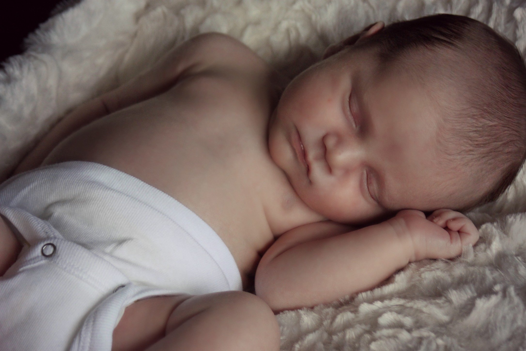 a baby sleeping on a blanket