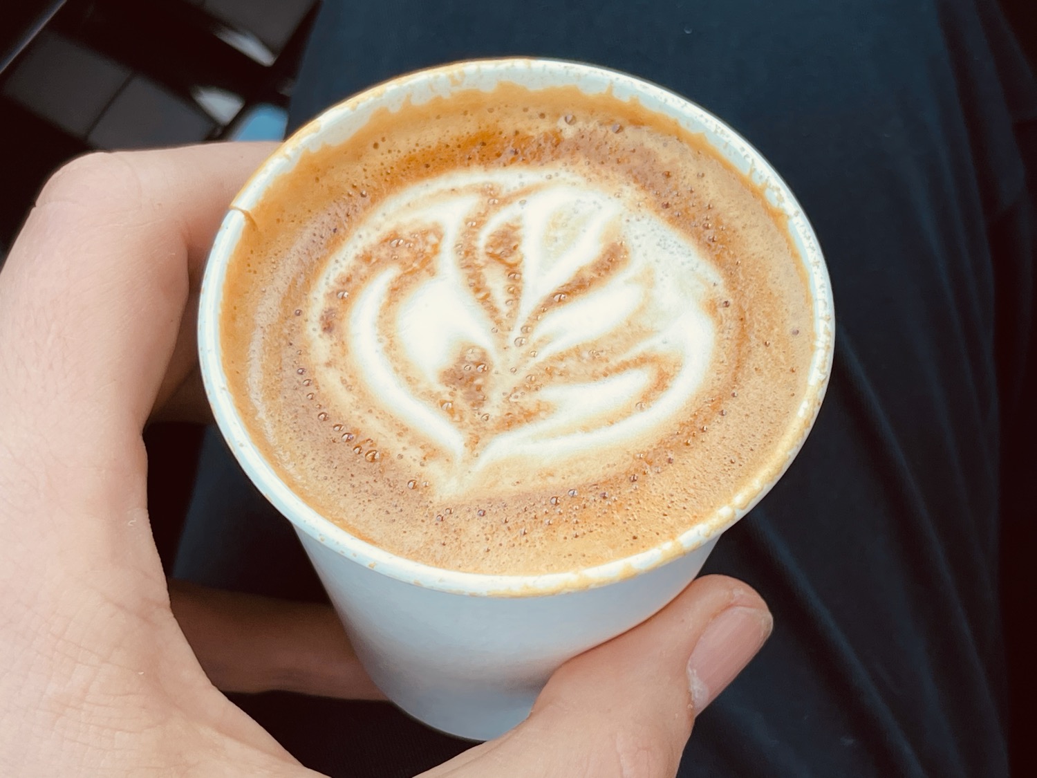 a hand holding a cup of coffee