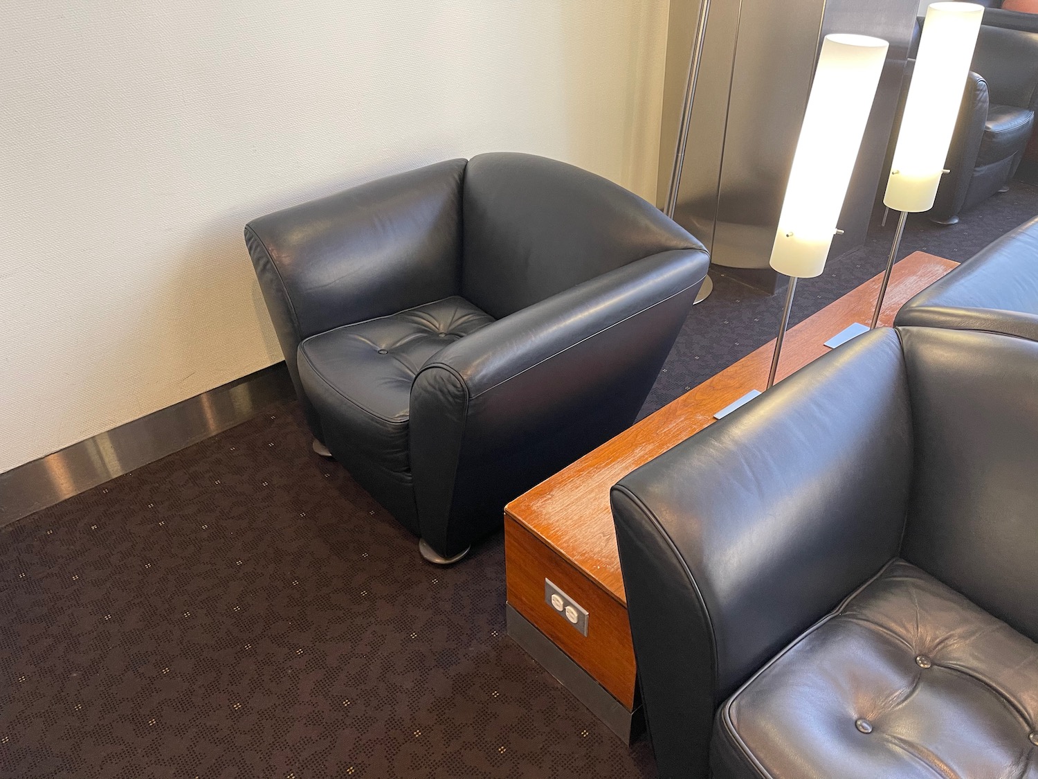 a black leather chair next to a wood table