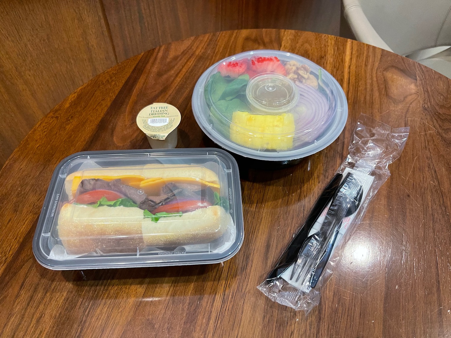 a sandwich and salad in plastic containers on a table