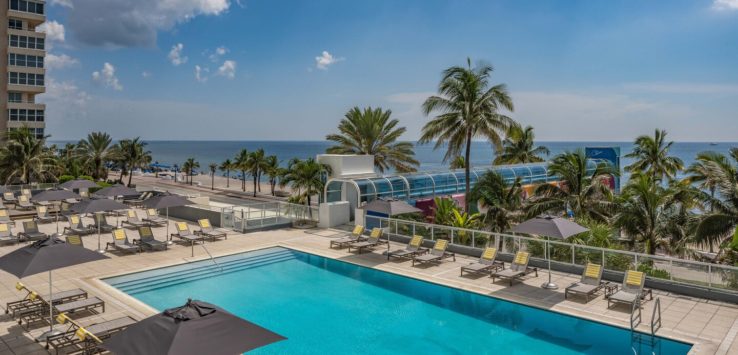 a pool with umbrellas and chairs on the side