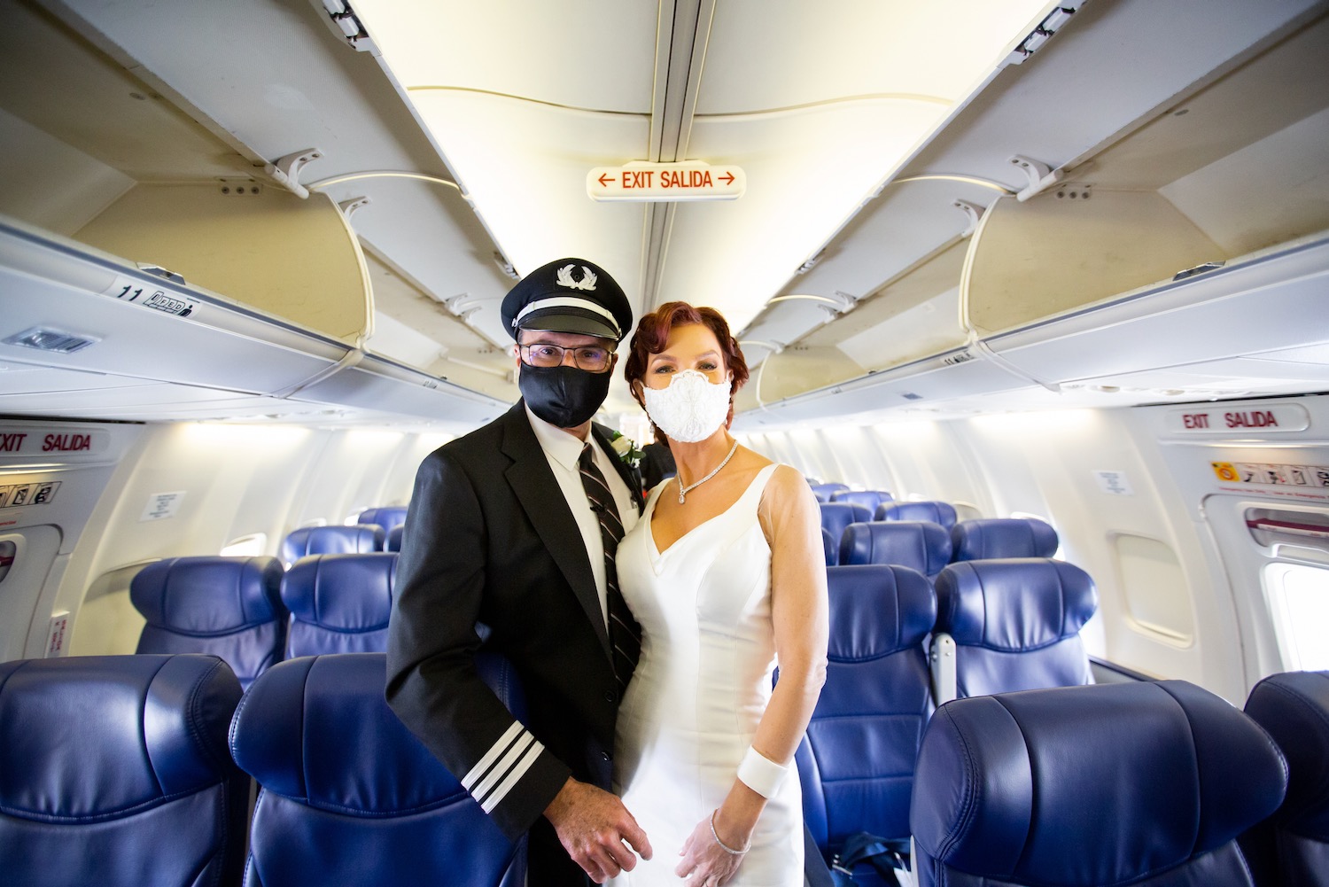 a man and woman wearing face masks in an airplane