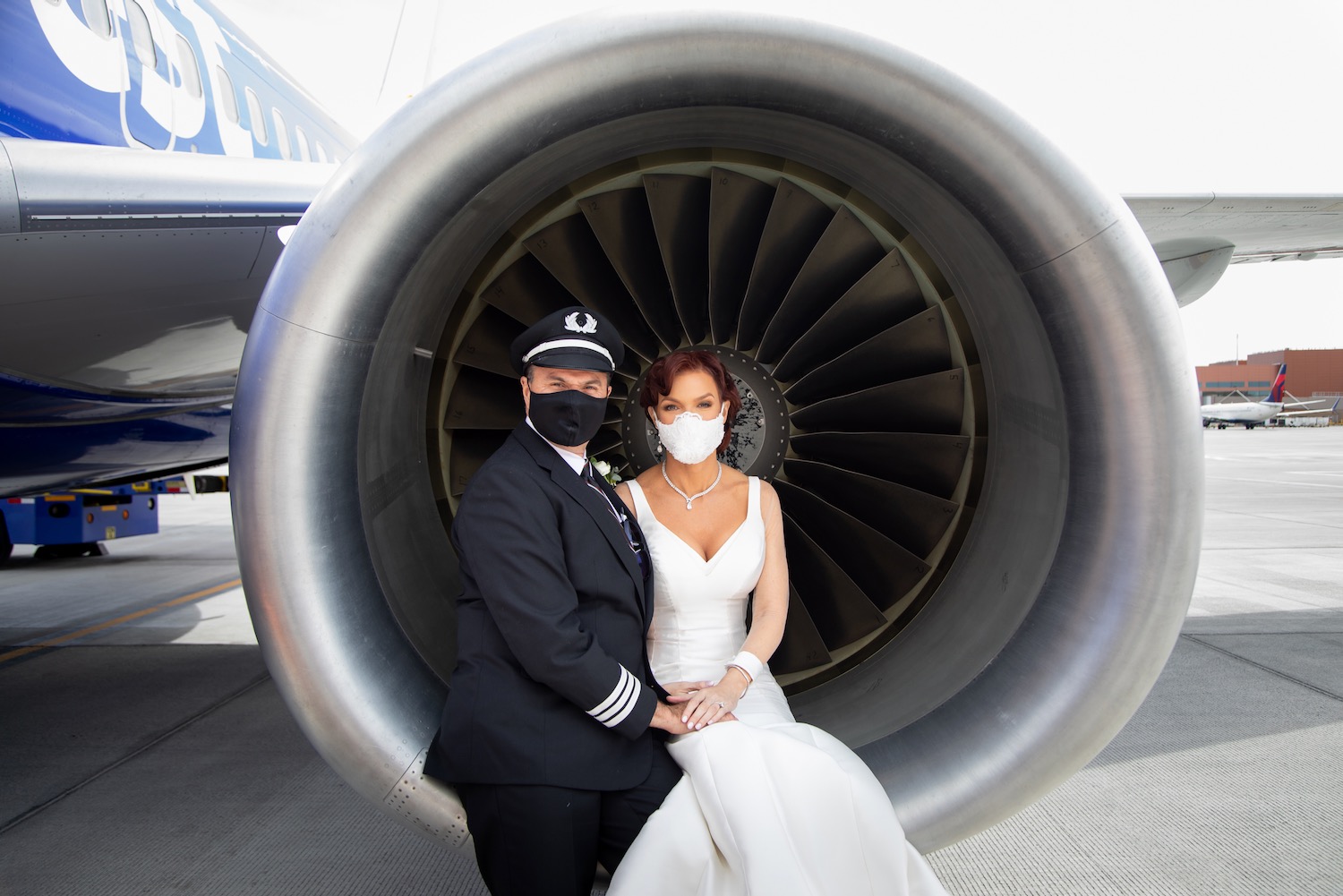 a man and woman wearing face masks and sitting in a jet engine