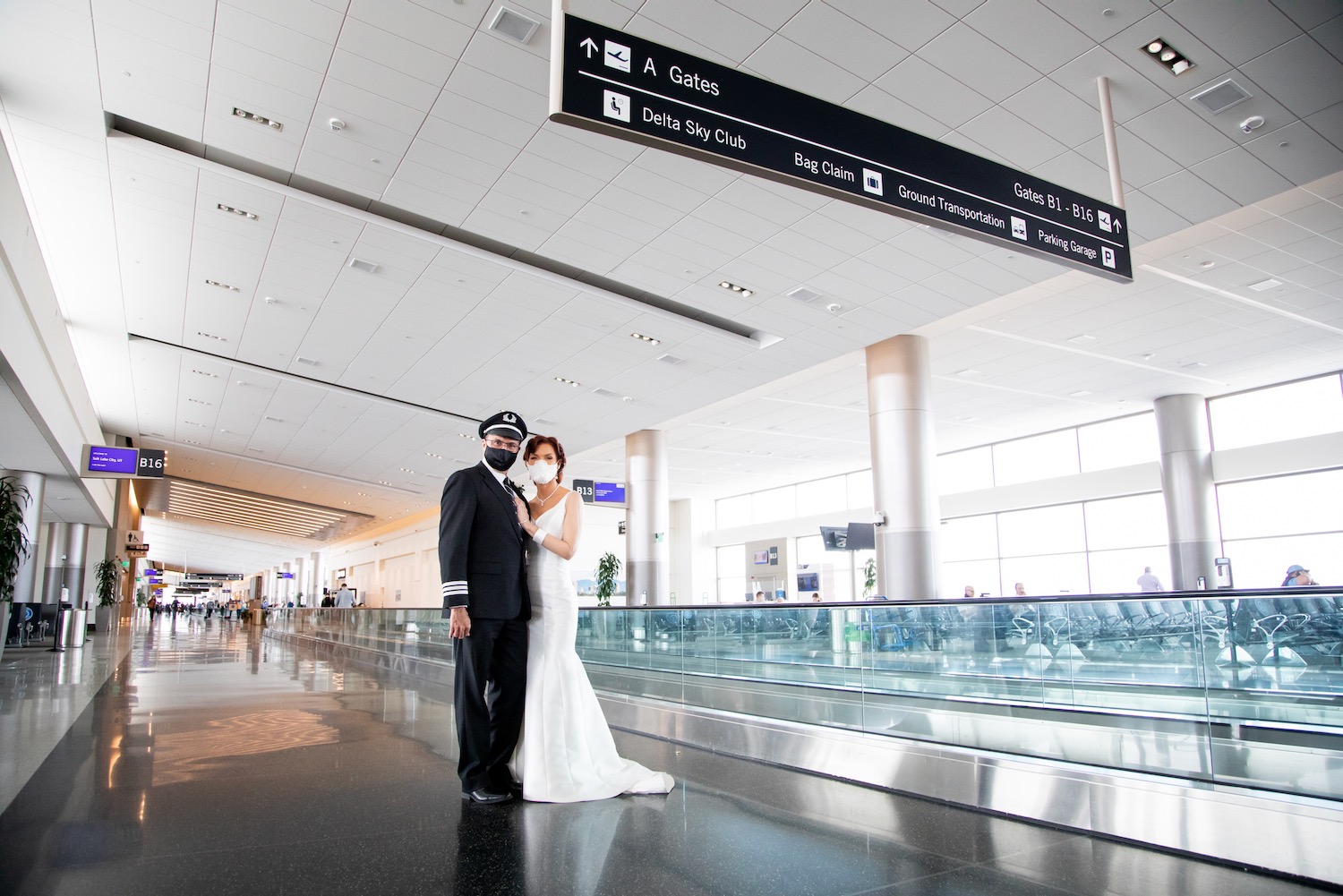 a man and woman in a white dress and a mask in an airport