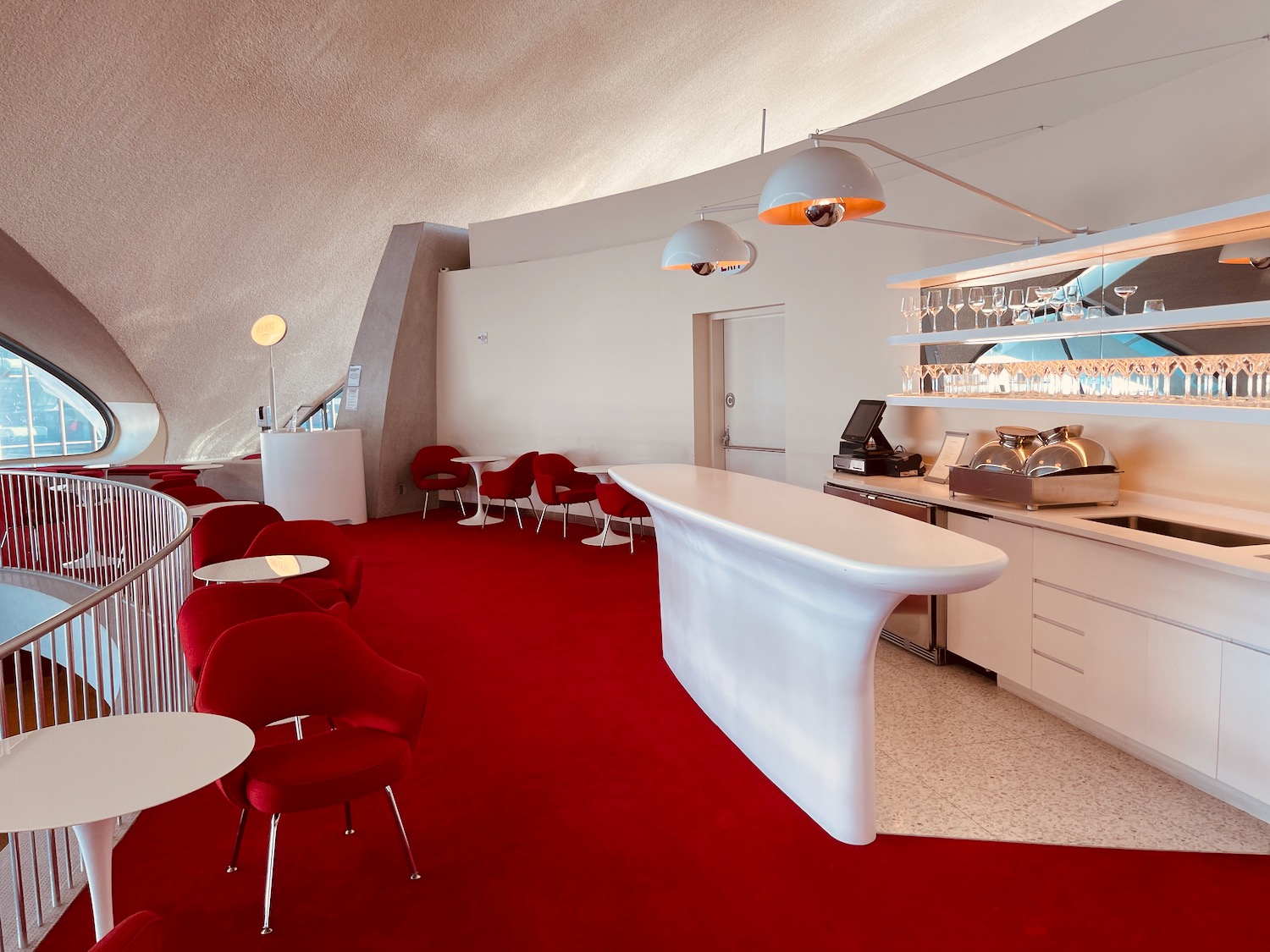 a room with red carpet and tables and chairs