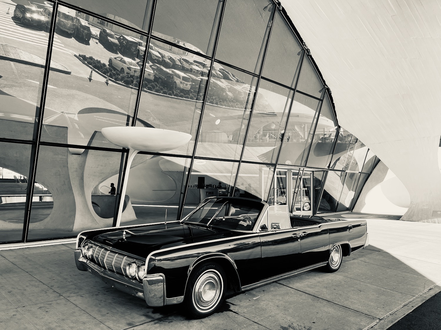 a car parked in front of a glass building