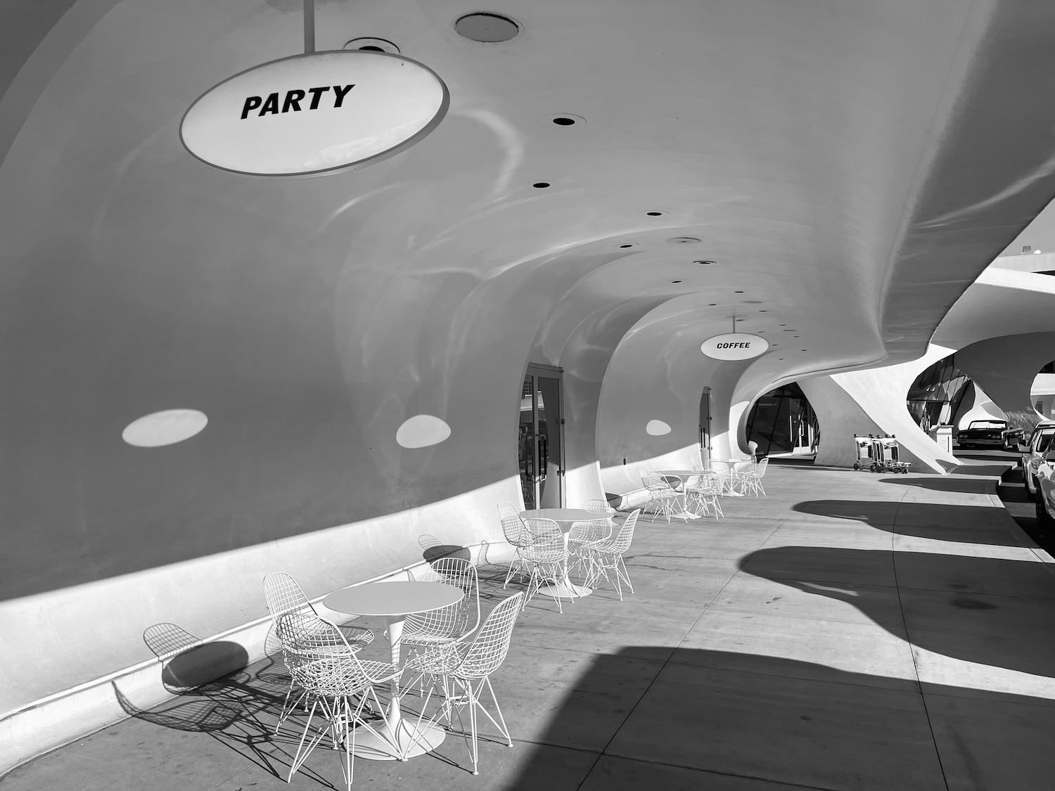 a white tables and chairs under a curved ceiling