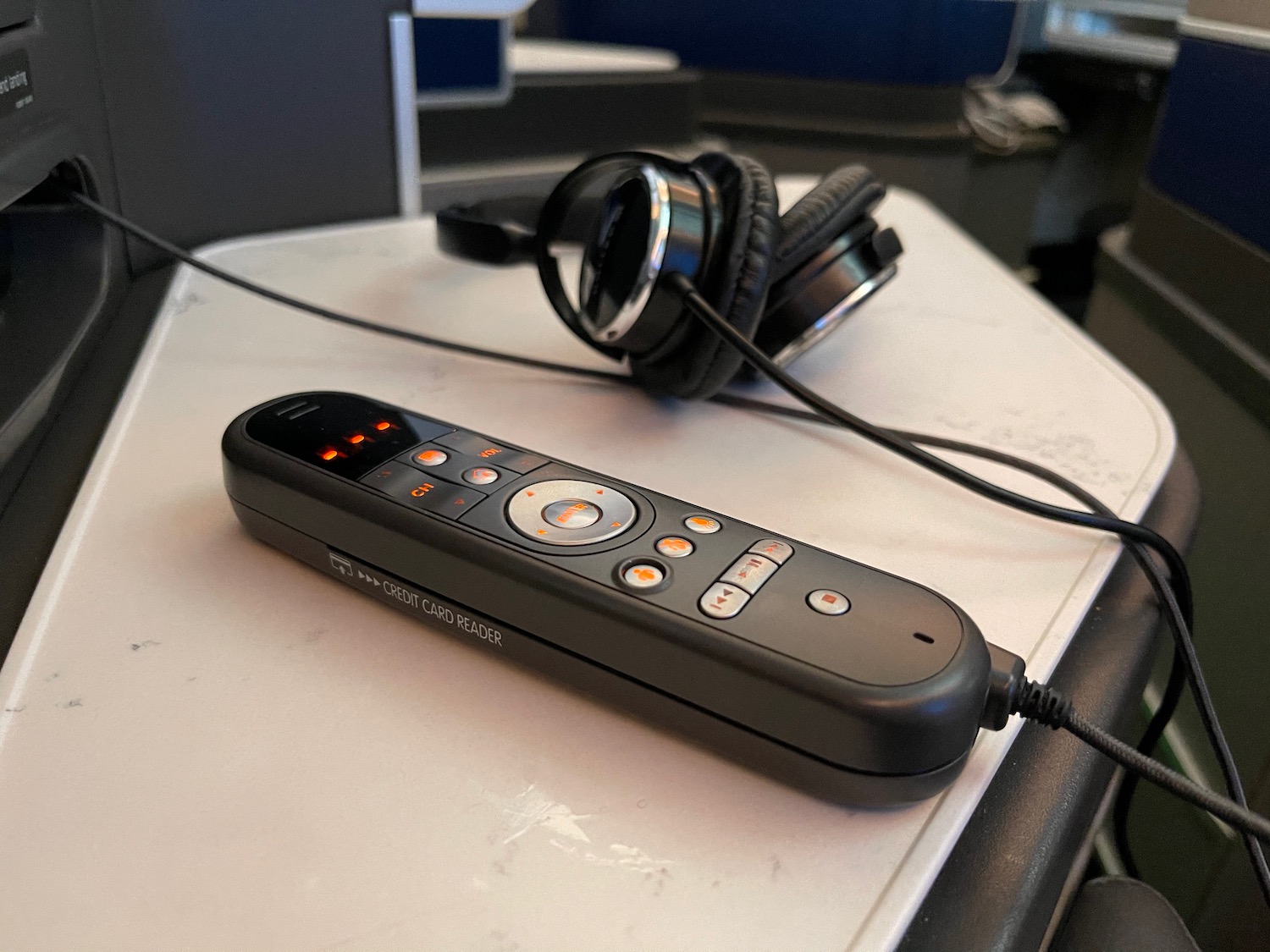 a remote control with buttons and headphones on a table