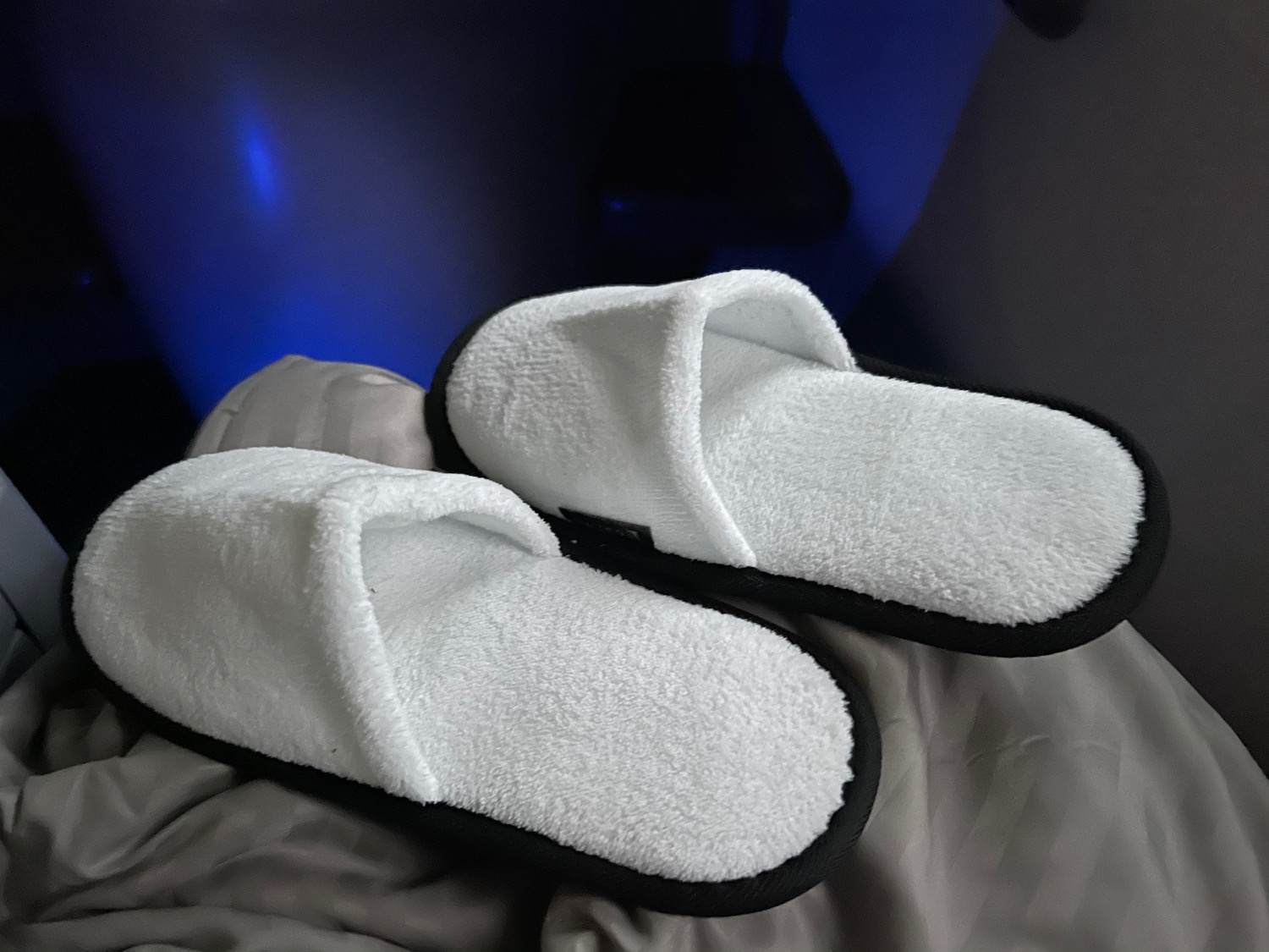 a pair of white slippers on a blanket