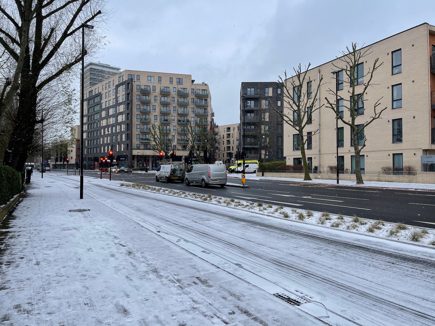 a snowy street with cars and buildings
