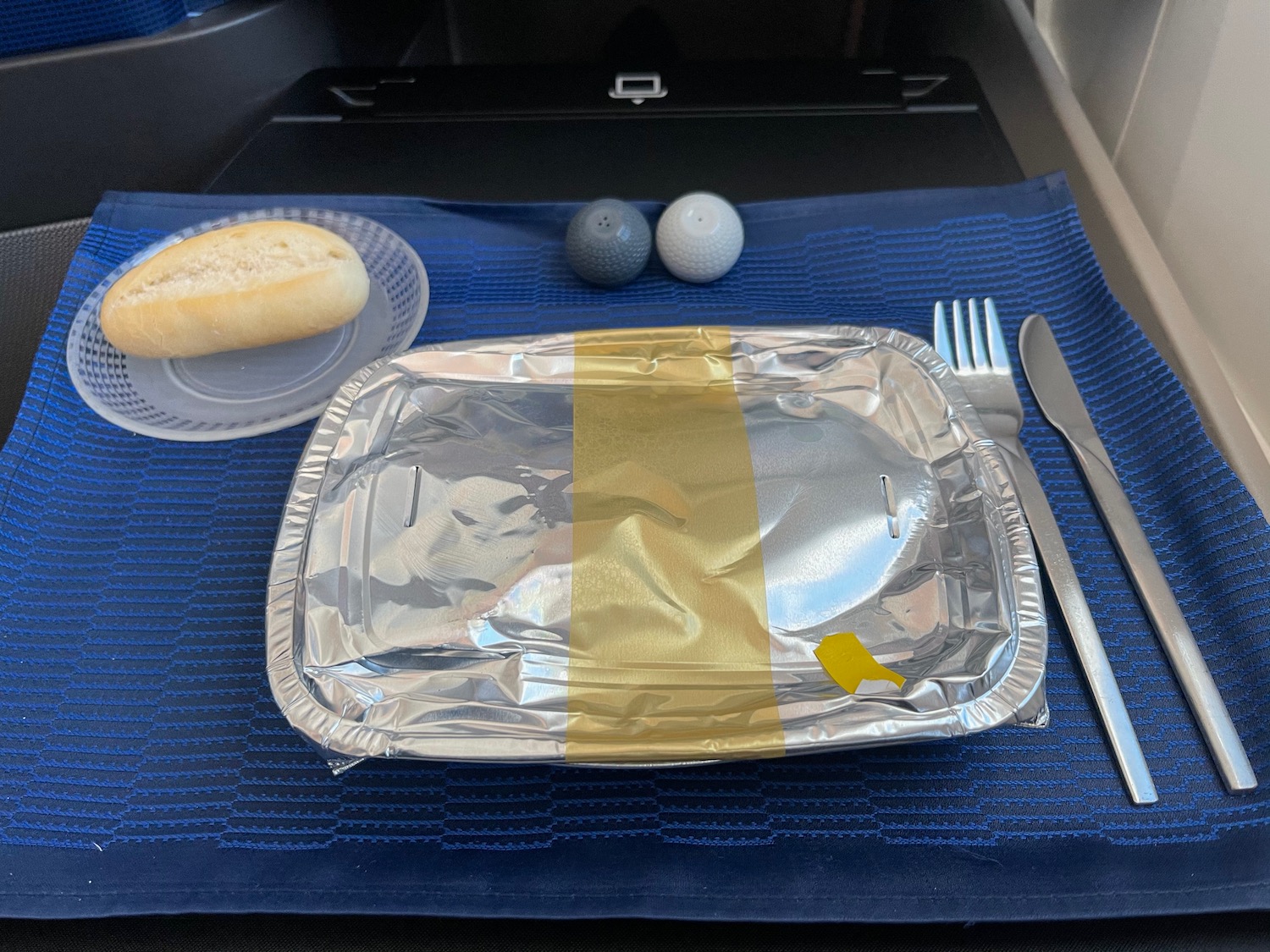 a tray with a fork and knife on a blue place mat