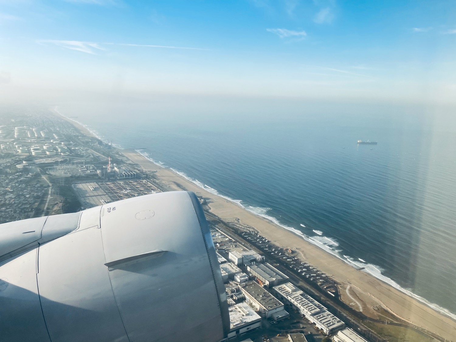 an airplane wing and engine of an airplane near the beach