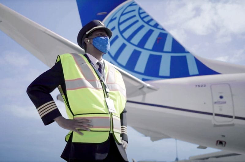 a man wearing a safety vest and a face mask