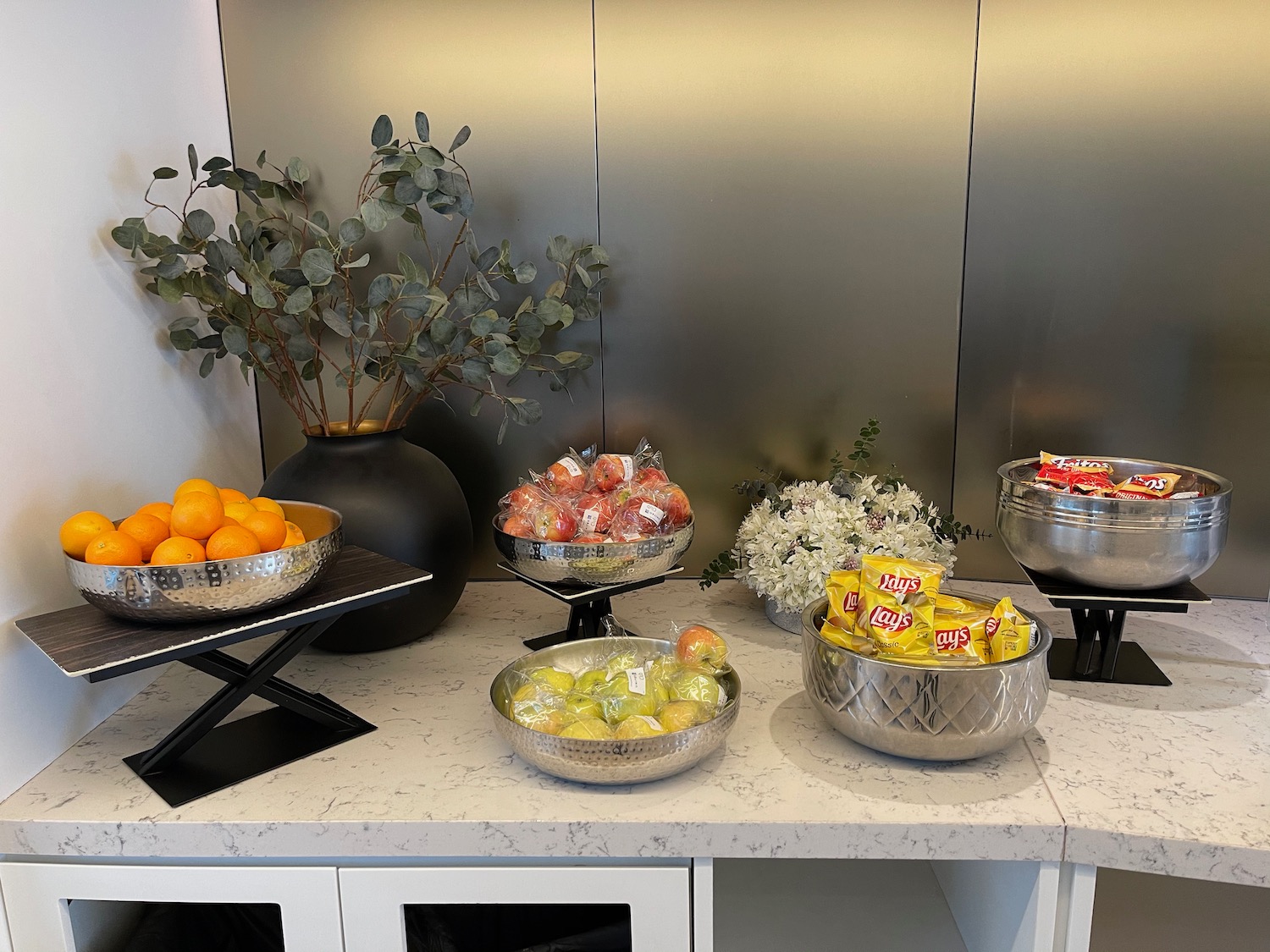 a group of bowls of fruit and candy on a counter