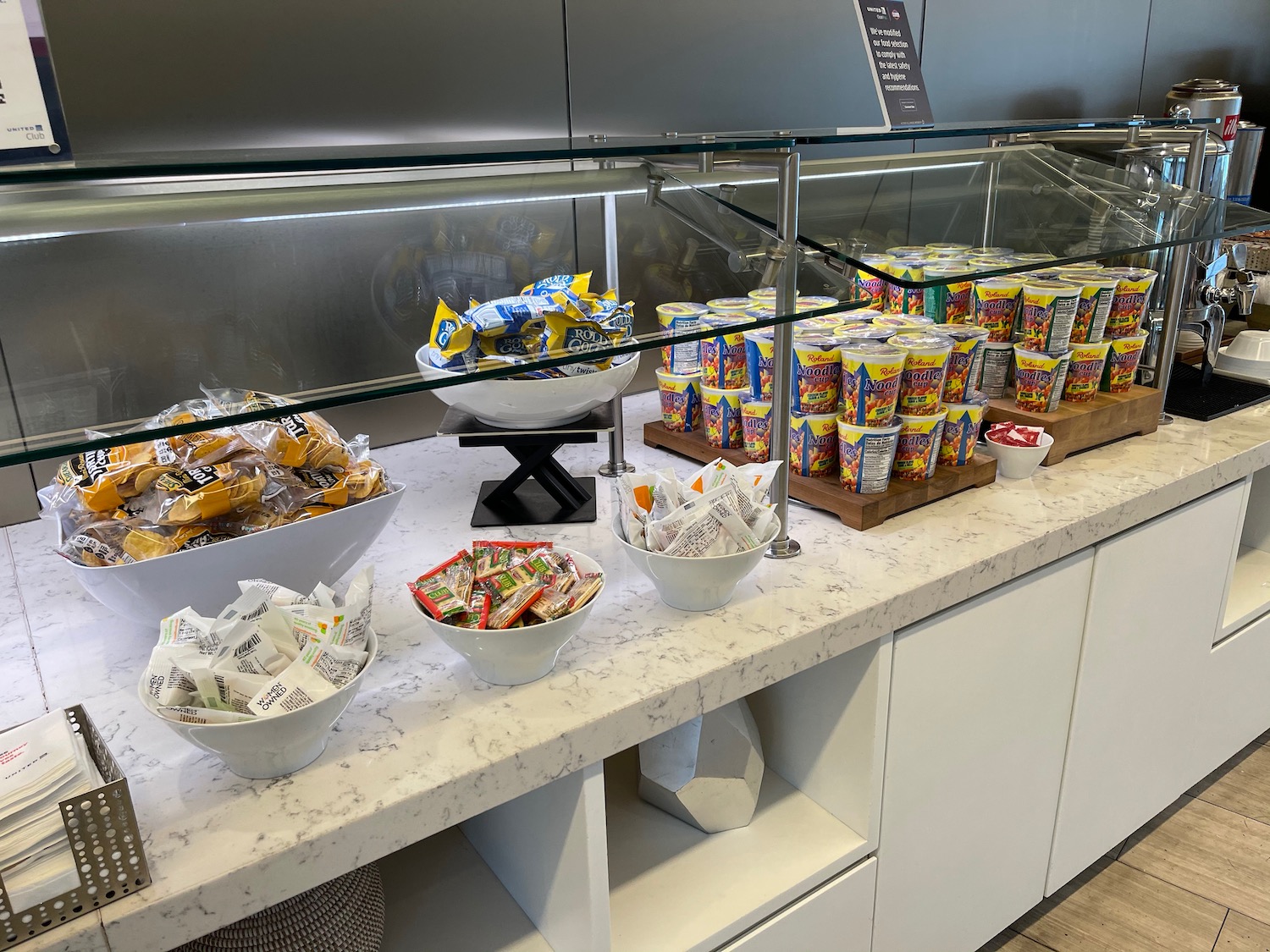 a counter with bowls of food and a glass display case