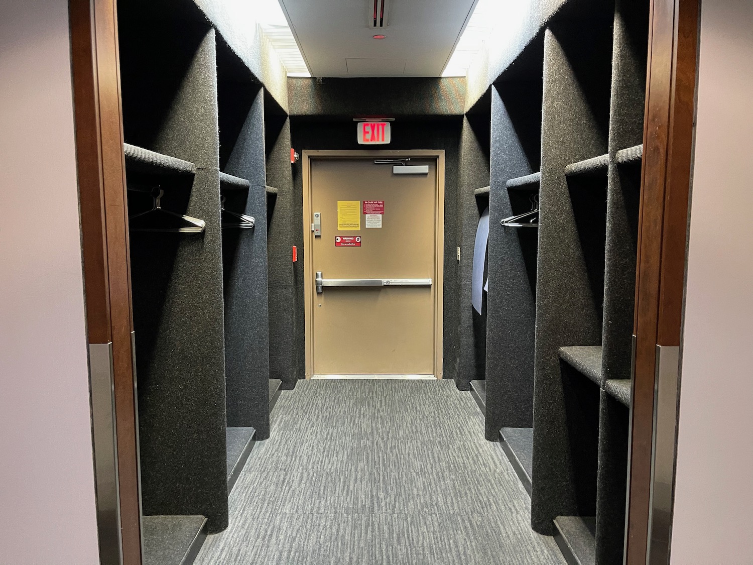 a hallway with a door and shelves