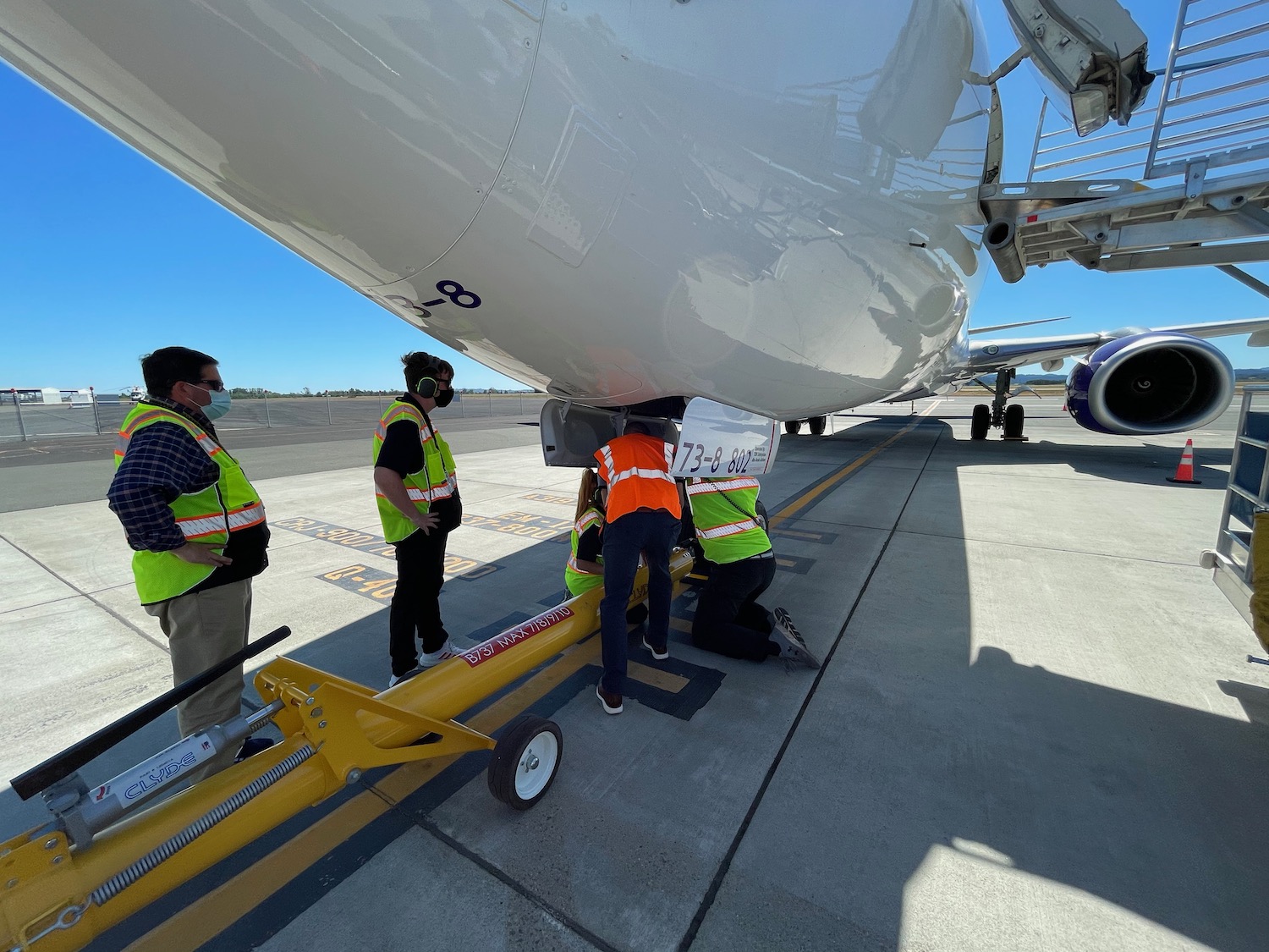 a group of people standing next to a plane