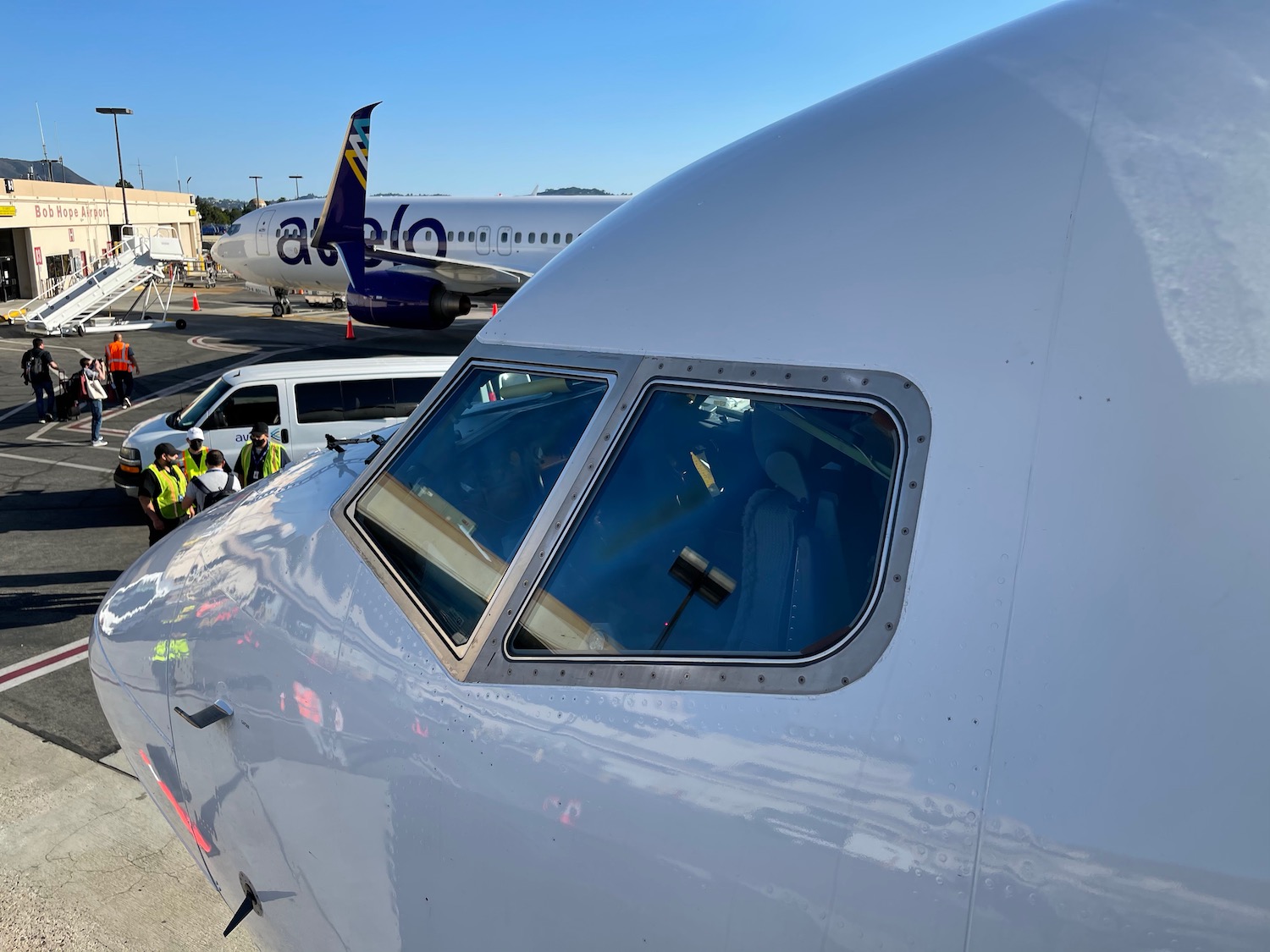 a plane with a pilot and people in the background