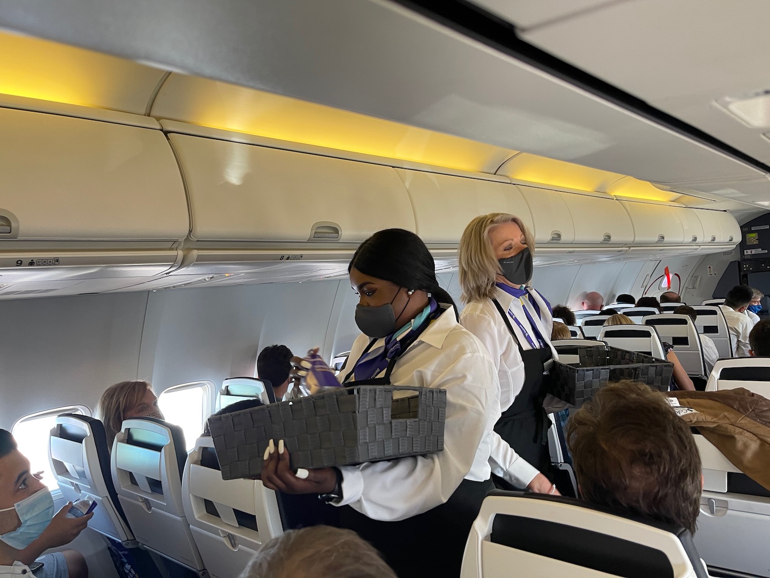 a group of people wearing masks and standing in an airplane