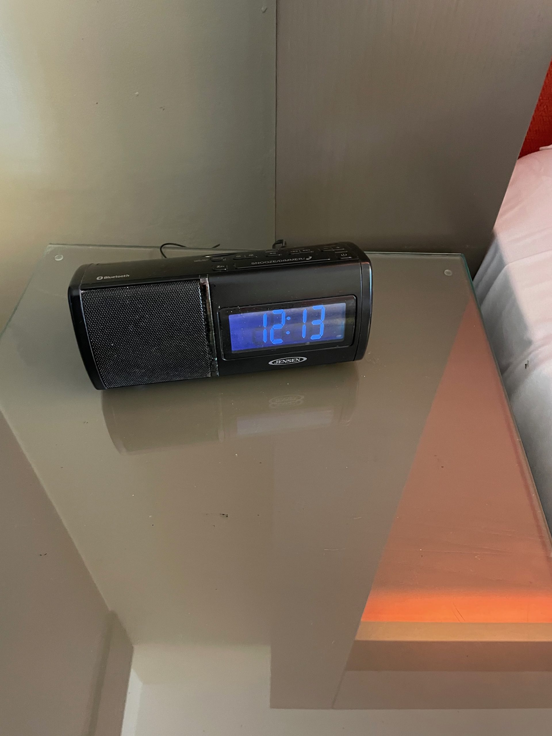 a black alarm clock on a glass table